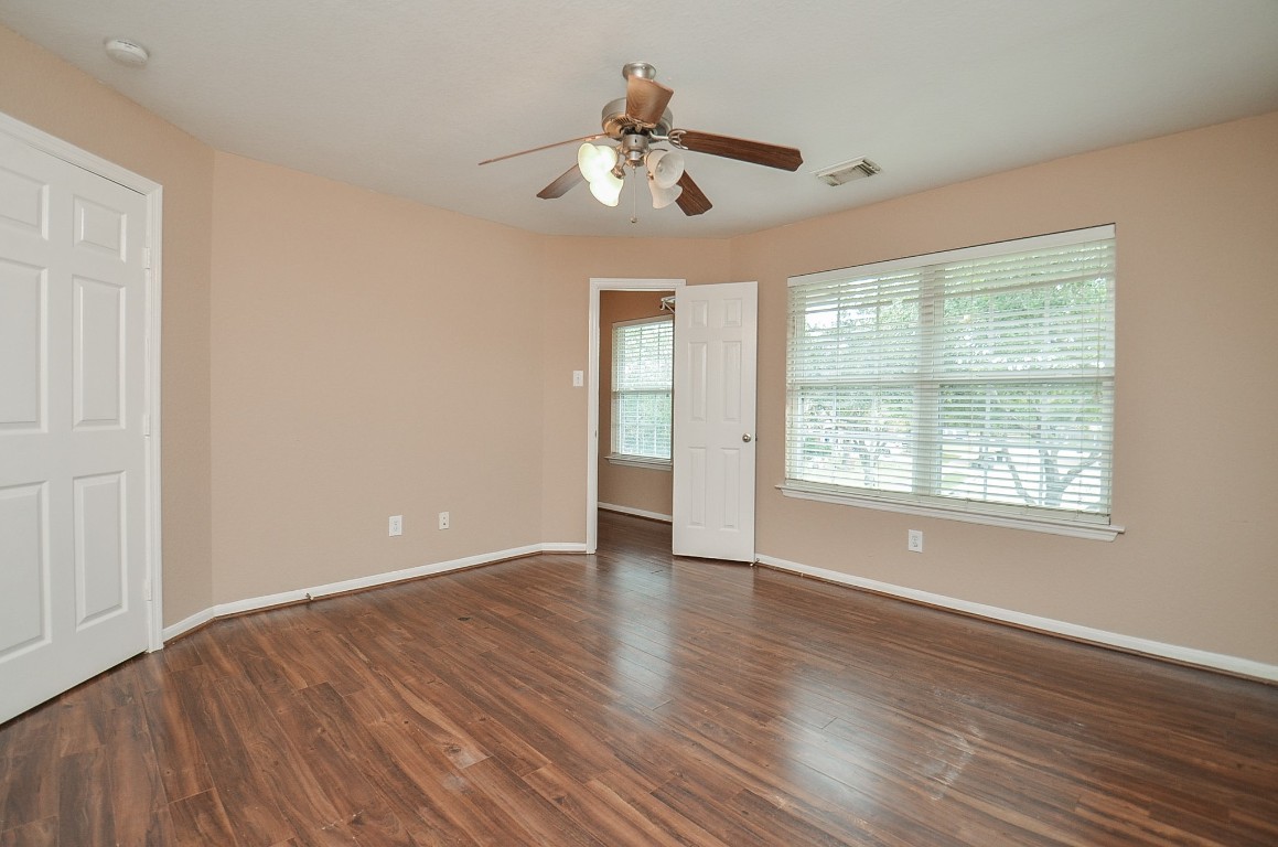 7134 Winston Ranch Parkway Richmond, TX 77406 - Photo 22 of 32 a view of an empty room with wooden floor and a window