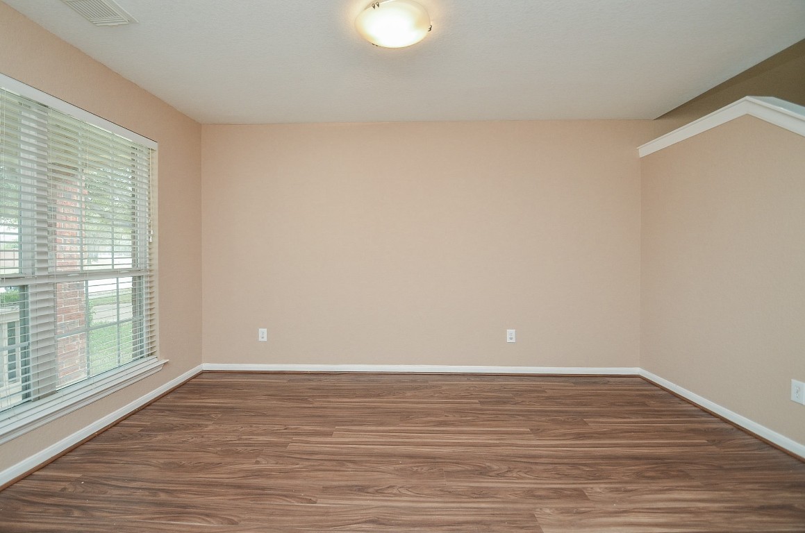 7134 Winston Ranch Parkway Richmond, TX 77406 - Photo 7 of 32 a view of an empty room with wooden floor and a window