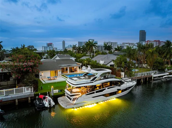 an aerial view of a house with swimming pool and lake view