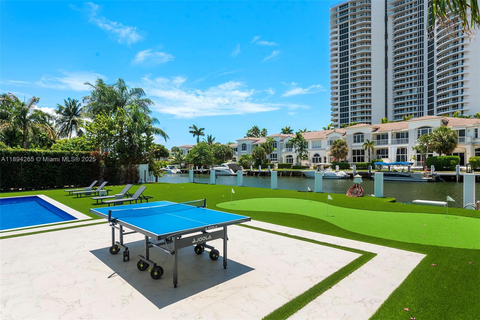 207 Holiday Drive Hallandale Beach, FL 33009 - Photo 16 of 50 a view of a swimming pool and lounge chairs in the patio