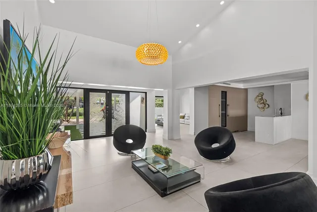 a living room with furniture potted plant and a large window