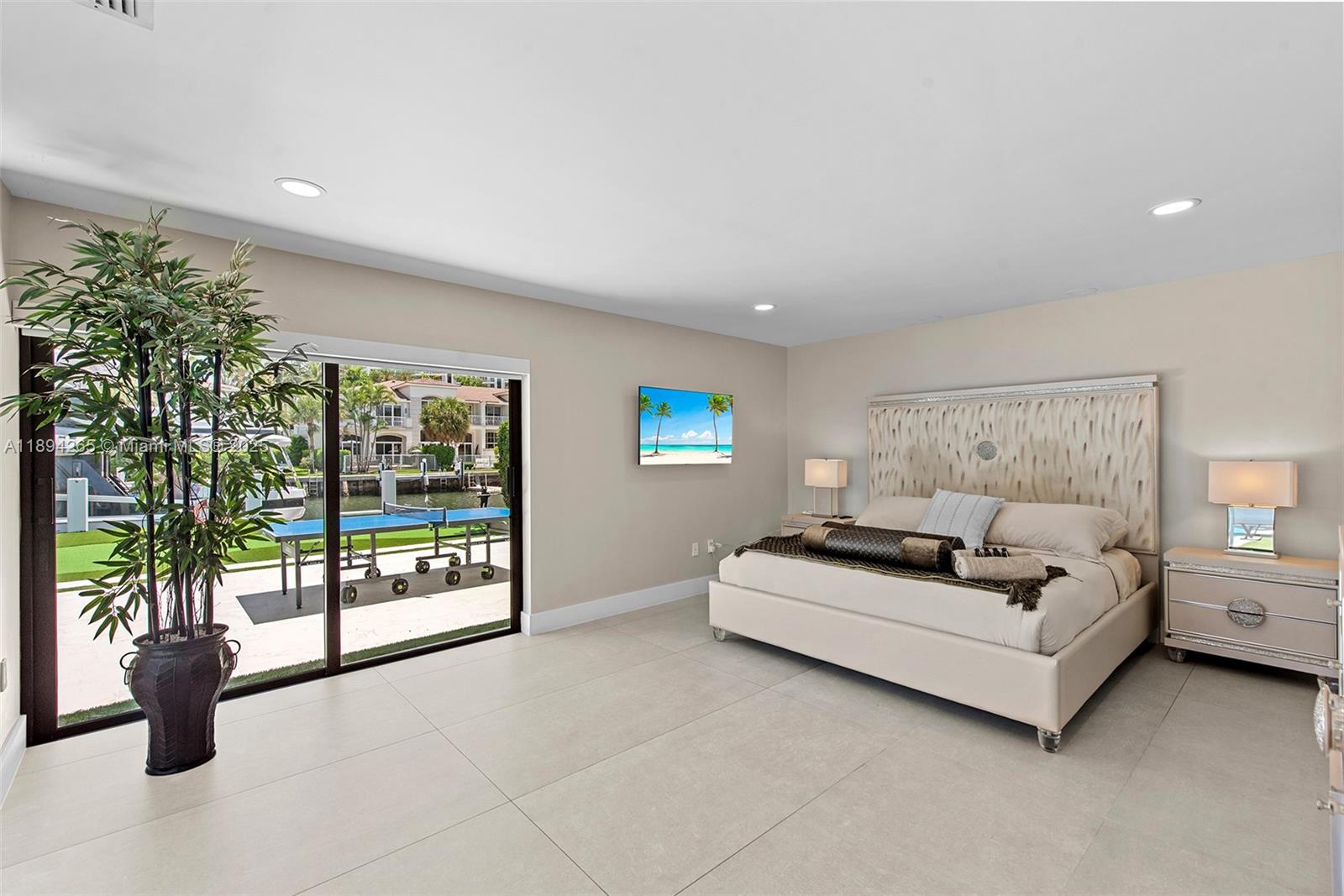 207 Holiday Drive Hallandale Beach, FL 33009 - Photo 34 of 50 a spacious bedroom with a bed and glass window