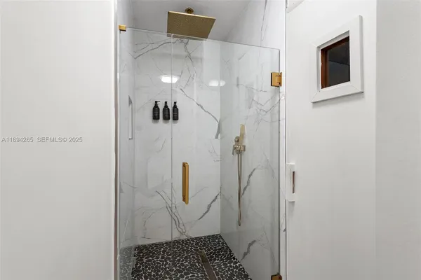 a large bed sitting in a bedroom next to a window and a chandelier