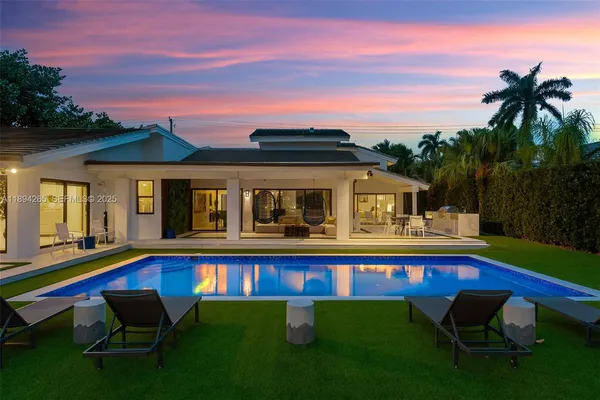 a aerial view of a house with swimming pool and yard