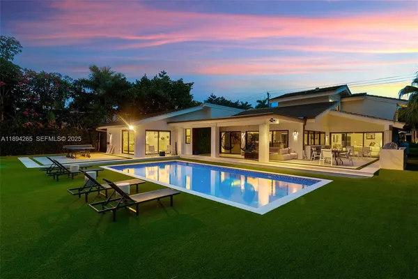 a view of house with swimming pool and yard