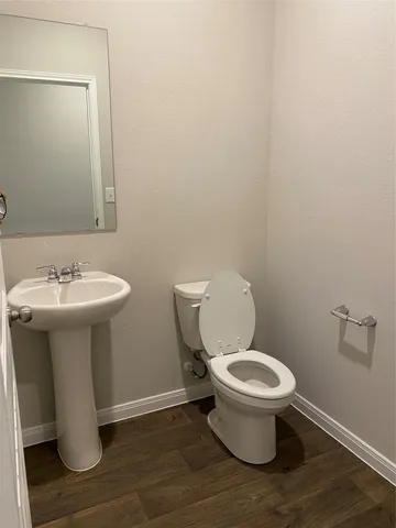 a kitchen with stainless steel appliances kitchen island granite countertop a sink and a stove top oven with wooden floor