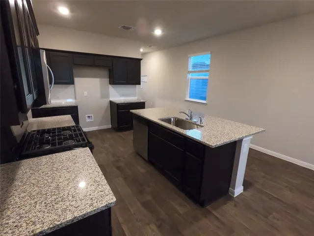 a kitchen with stainless steel appliances granite countertop a sink stove and refrigerator