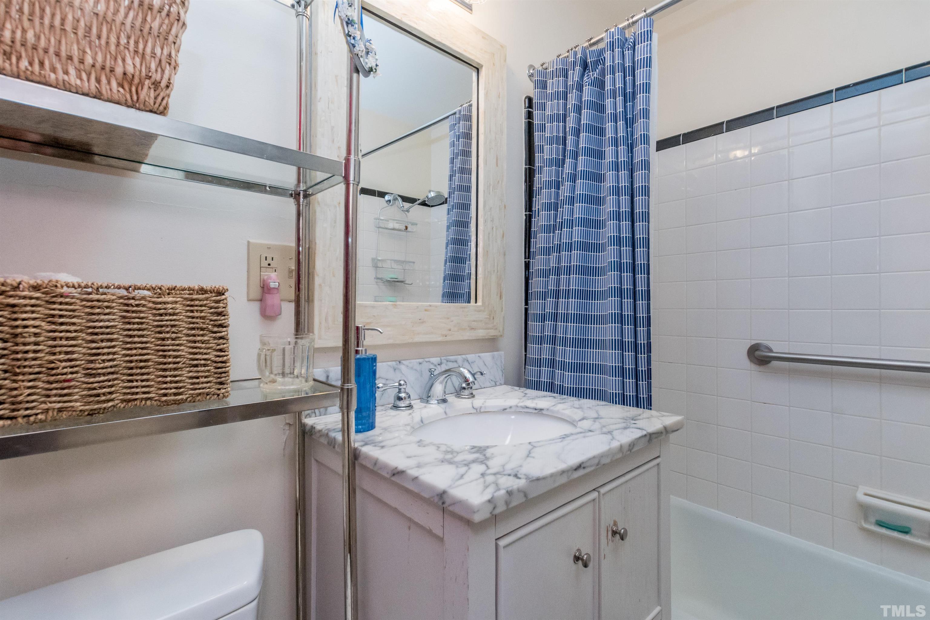 2601 London Drive Raleigh, NC 27608 - Photo 18 of 30 a bathroom with a granite countertop sink a toilet and shower