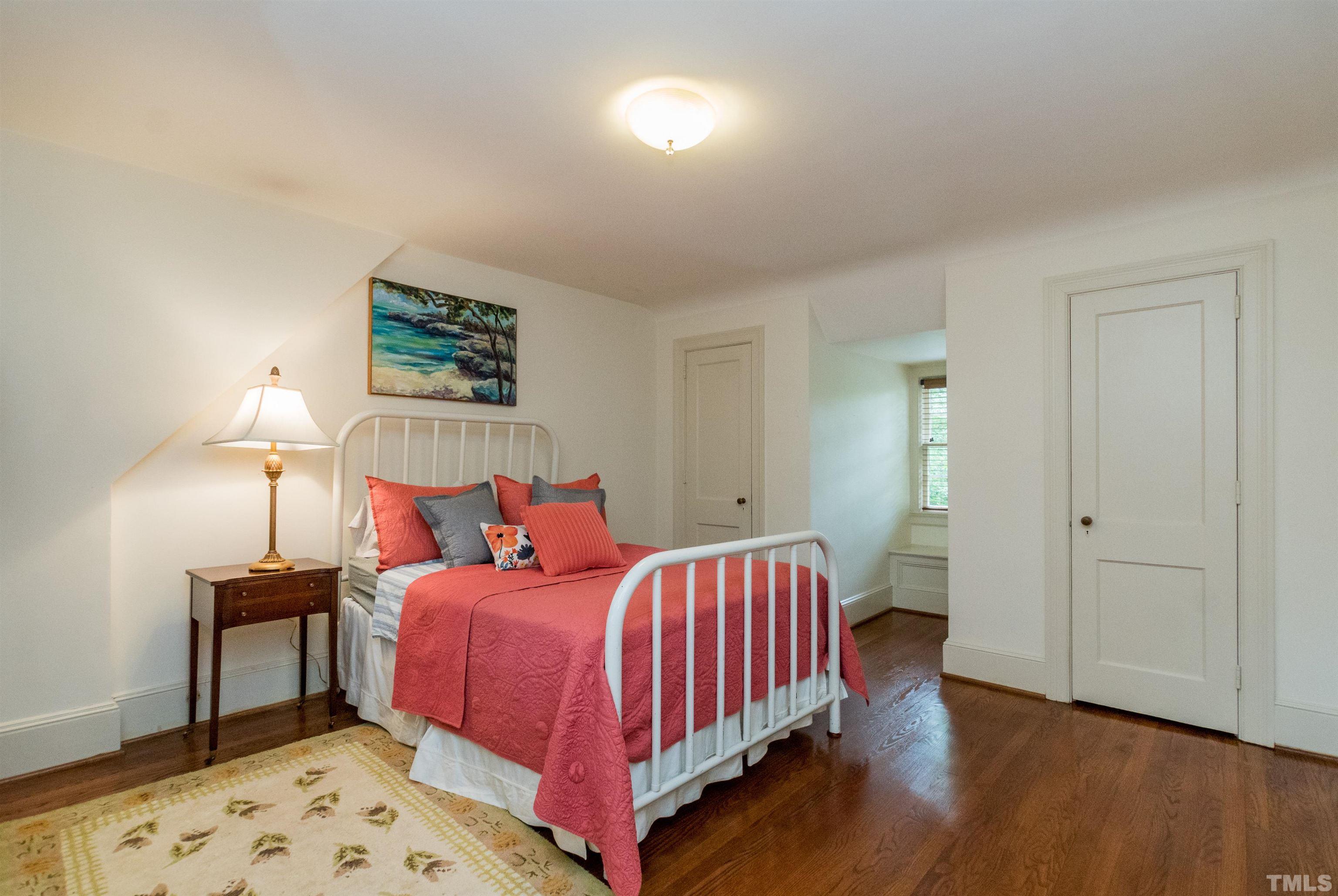 2601 London Drive Raleigh, NC 27608 - Photo 21 of 30 a bedroom with a bed and a lamp