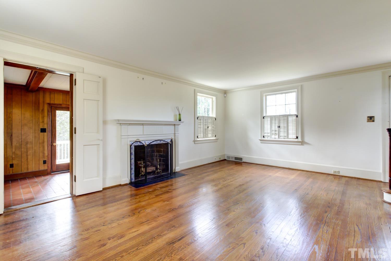 2601 London Drive Raleigh, NC 27608 - Photo 6 of 30 an empty room with wooden floor fireplace and windows