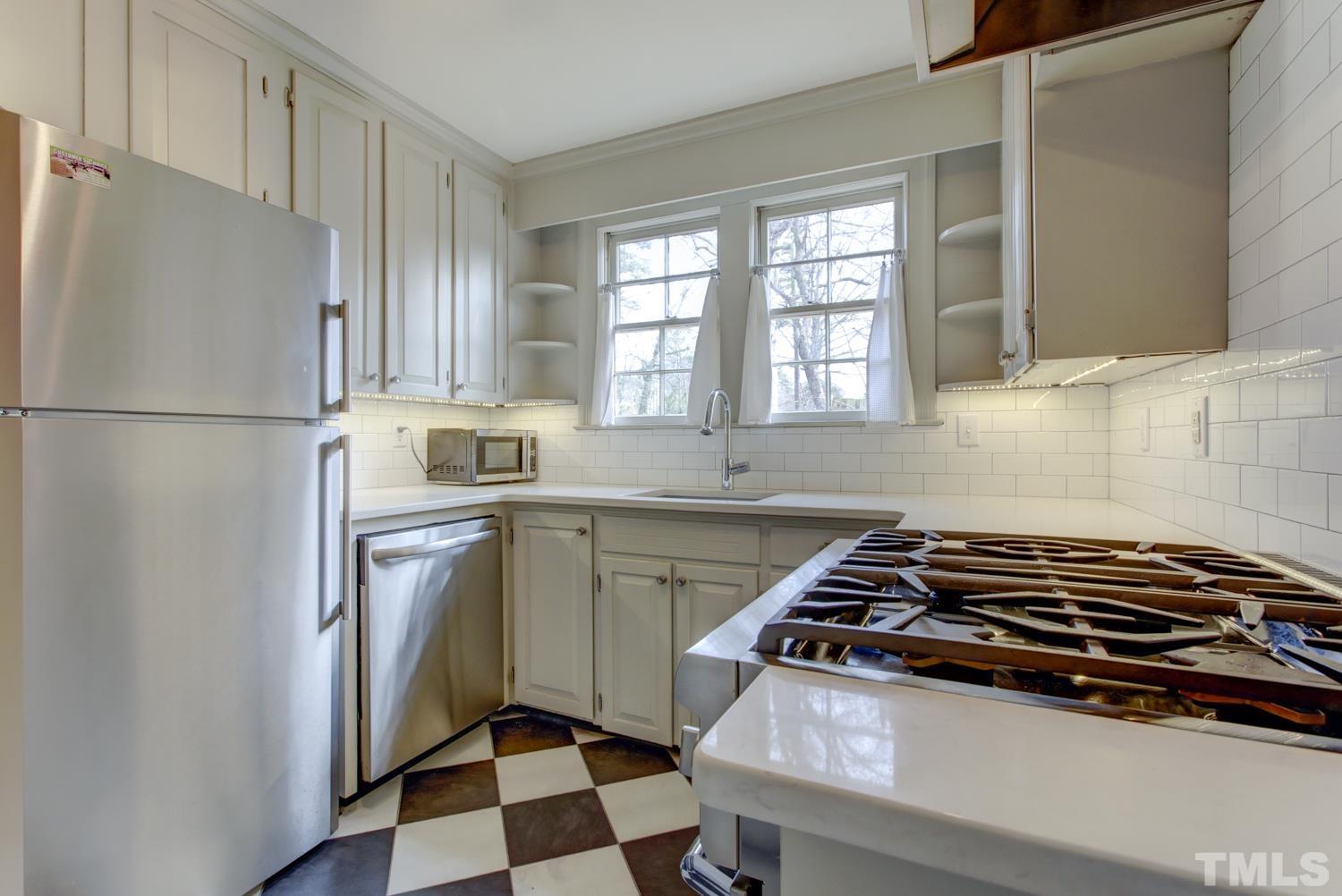 2601 London Drive Raleigh, NC 27608 - Photo 7 of 30 a kitchen with a stove a sink and a refrigerator