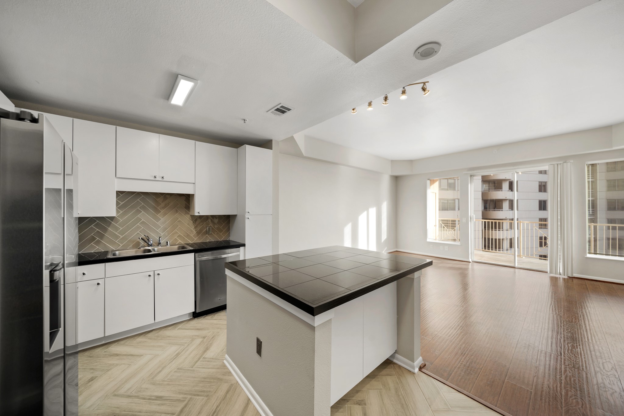 a kitchen with granite countertop a sink a stove and refrigerator