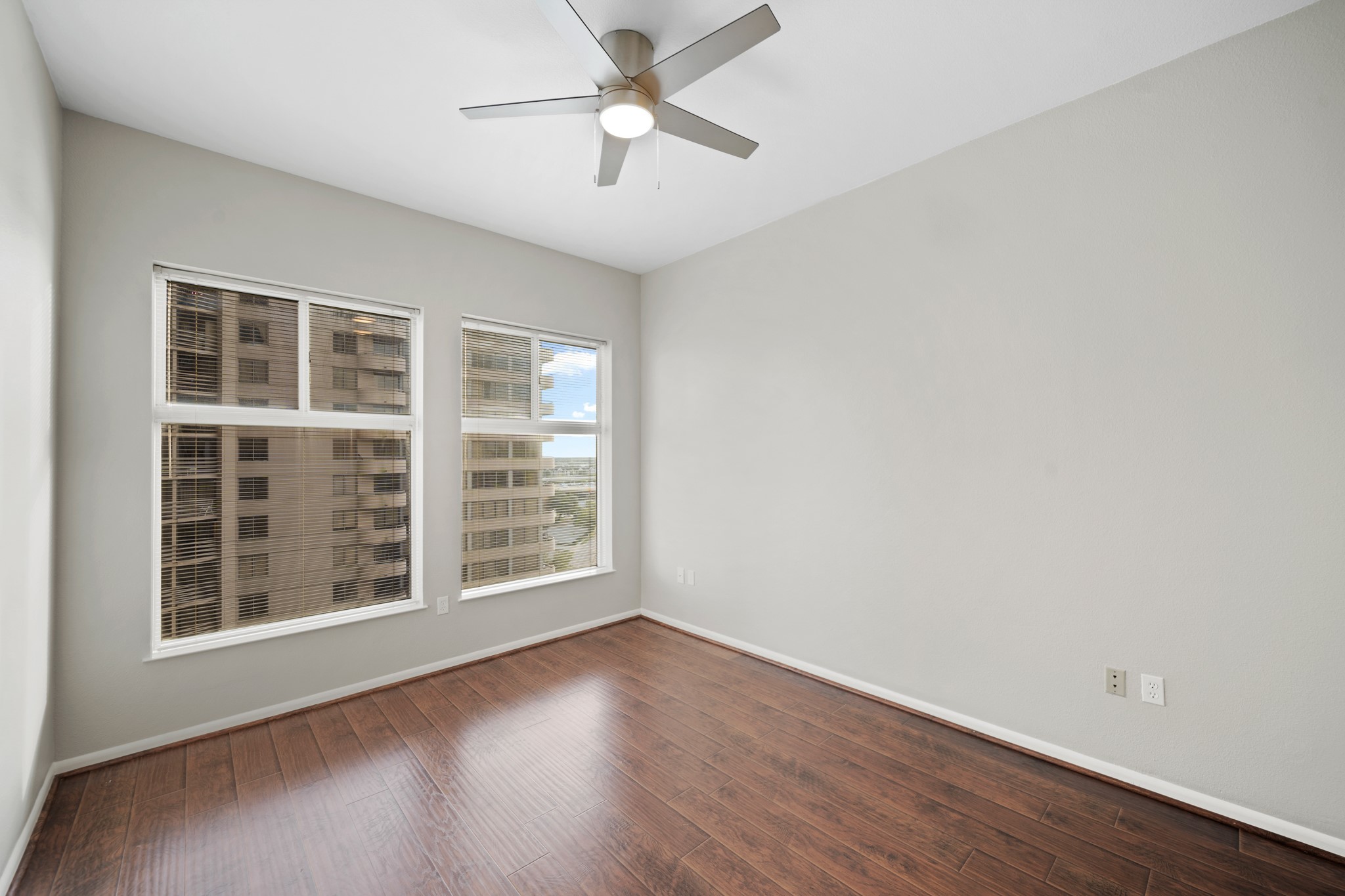 3505 Sage Road, Unit 1004 Houston, TX 77056 - Photo 11 of 17 an empty room with wooden floor chandelier fan and windows