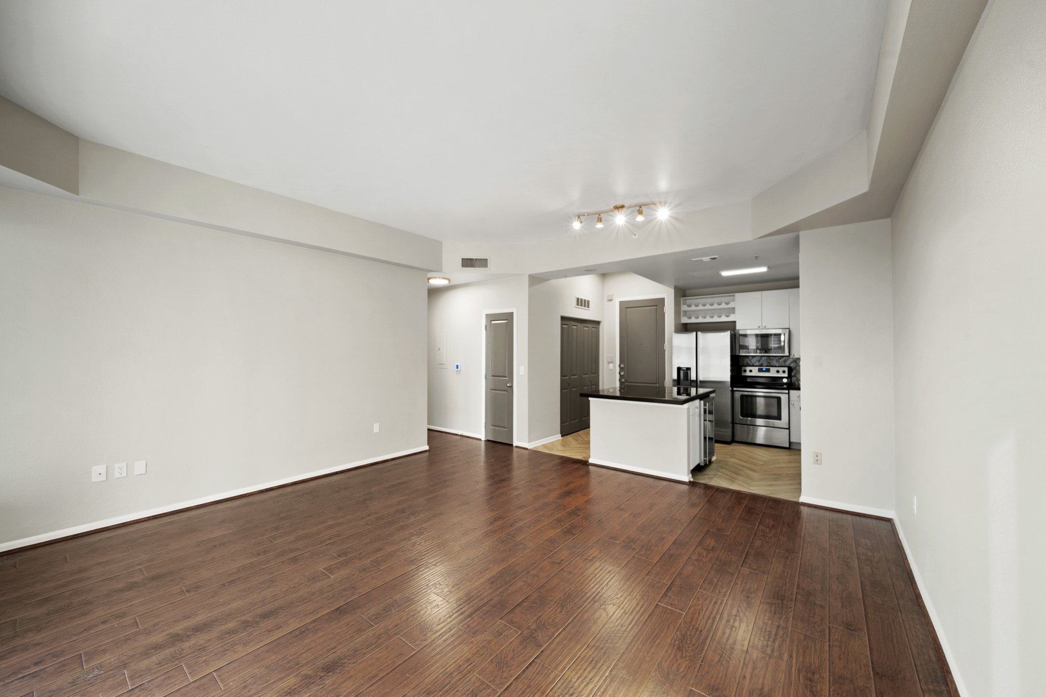 3505 Sage Road, Unit 1004 Houston, TX 77056 - Photo 8 of 17 a view of an empty room with wooden floor and a kitchen