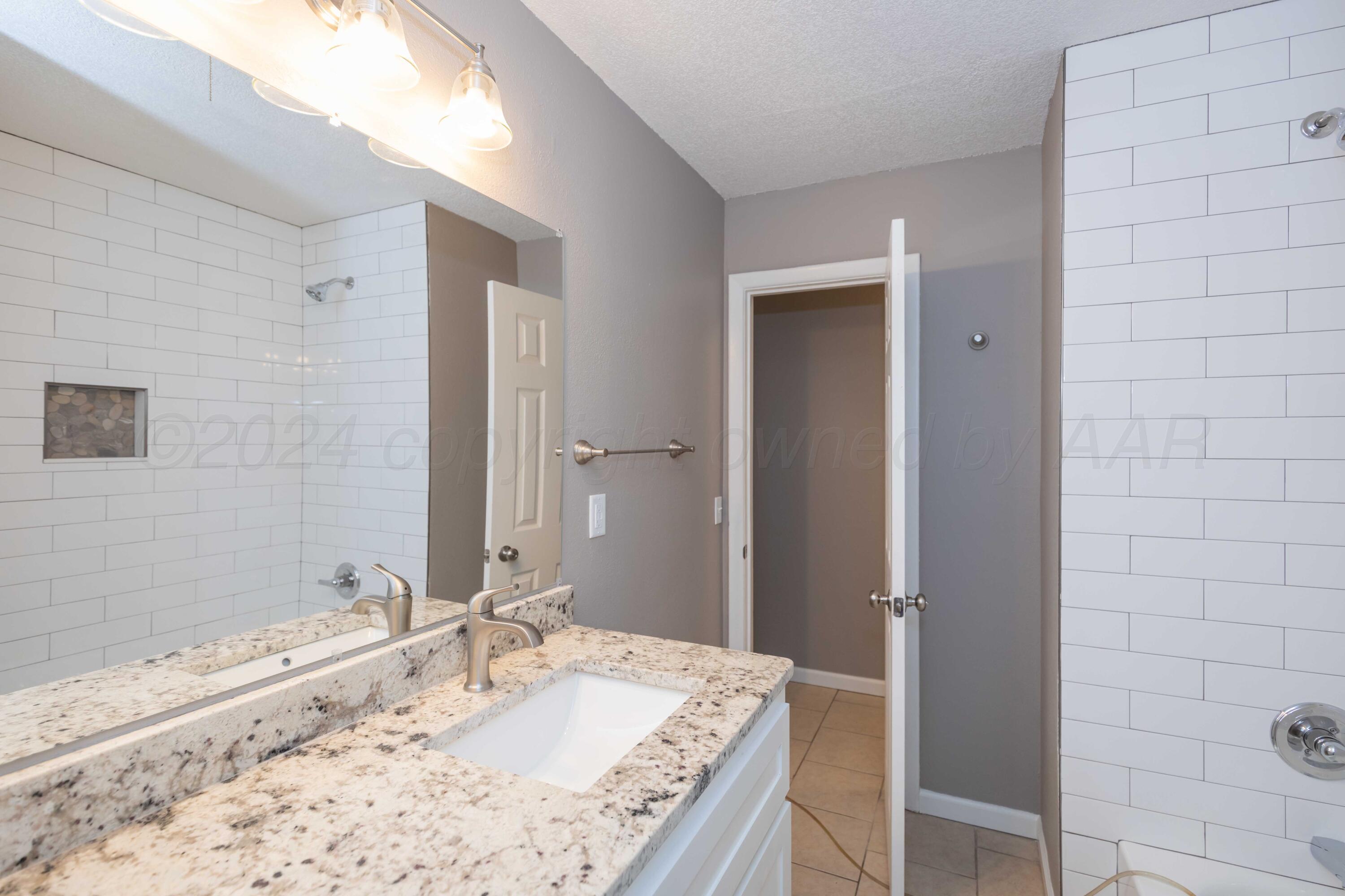 402 Beech Street Borger, TX 79007 - Photo 23 of 41 a bathroom with a granite countertop sink and a bathtub