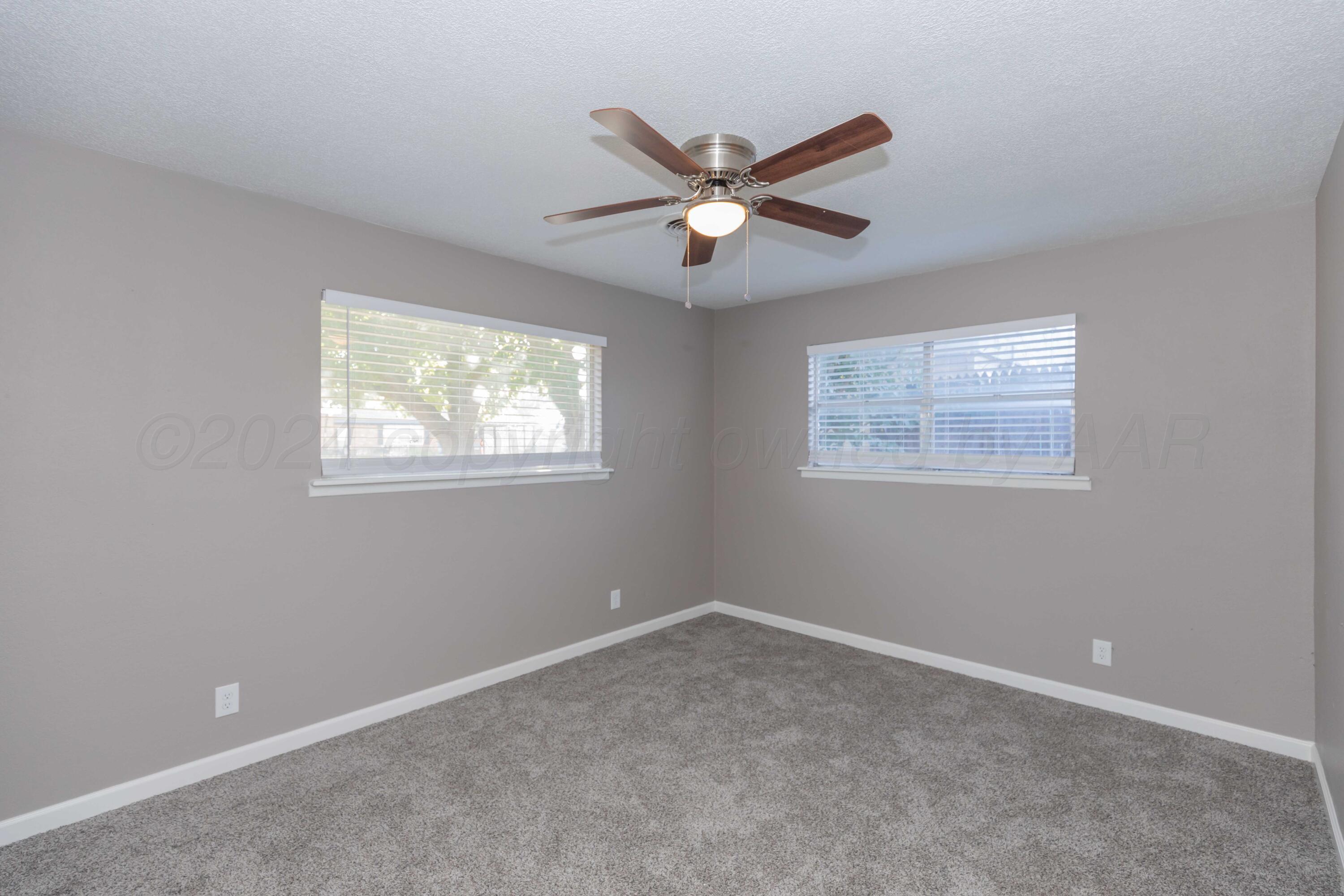 402 Beech Street Borger, TX 79007 - Photo 28 of 41 a view of a big room with windows and chandelier fan