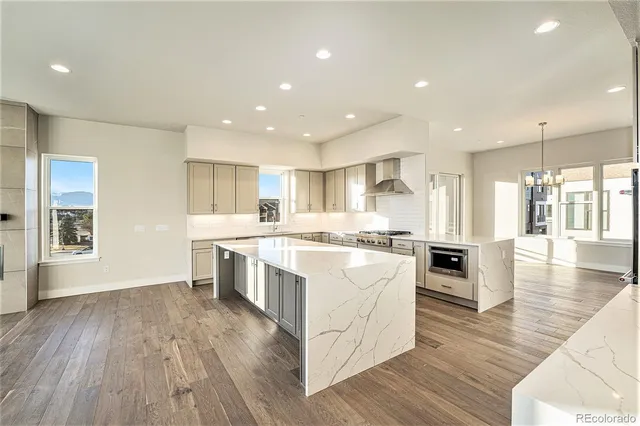 a large kitchen with stainless steel appliances granite countertop a large center island and a wooden floors