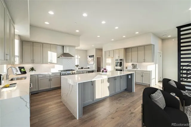 a kitchen with white cabinets stove and sink