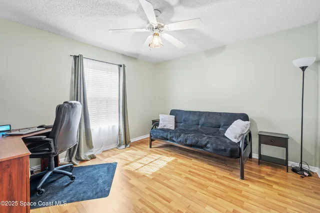a living room with a couch piano and a desk