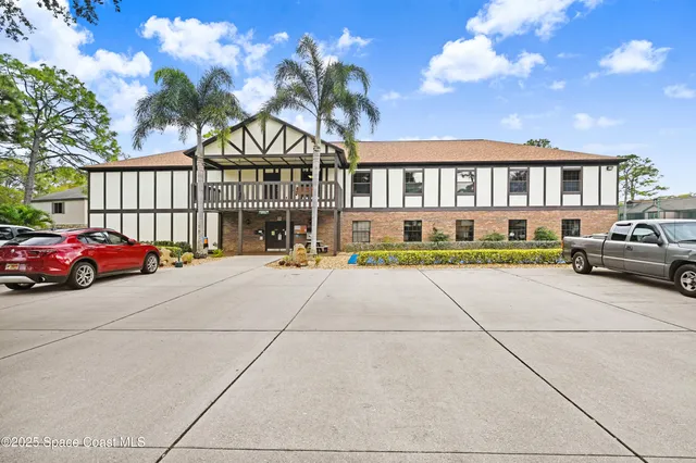 a front view of a house with a garden and trees