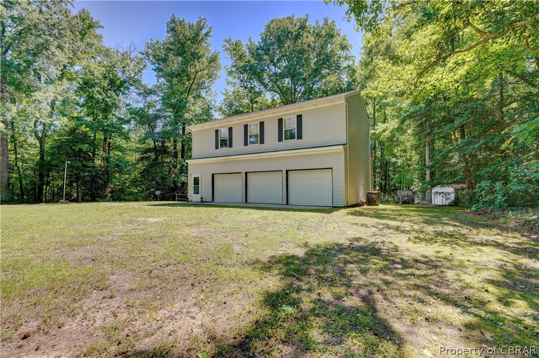 8269 Ark Road Gloucester, VA 23061 - Photo 4 of 33 View of front facade featuring a front lawn, a garage, and a storage unit