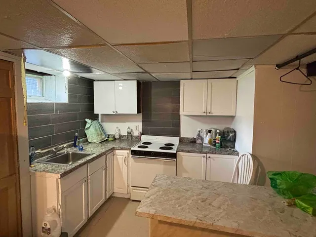 a kitchen with granite countertop a sink a stove and cabinets
