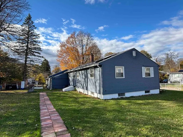 a backyard of a house with table and chairs