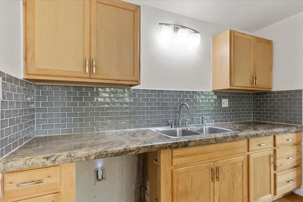 a kitchen with granite countertop a sink a stove and cabinets