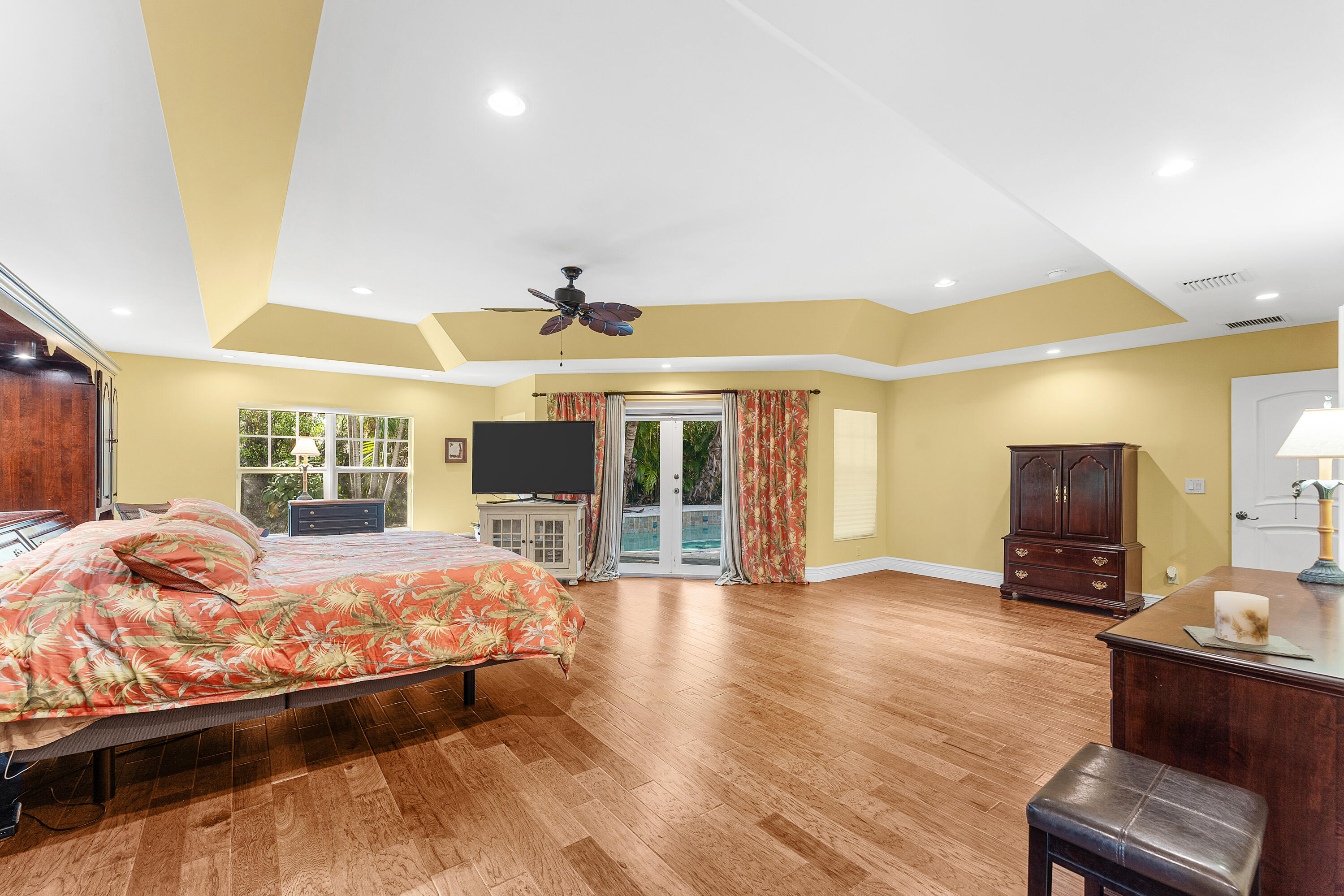 10295 St Andrews Road Boynton Beach, FL 33436 - Photo 18 of 43 a bedroom with a bed wooden floor and flat screen tv