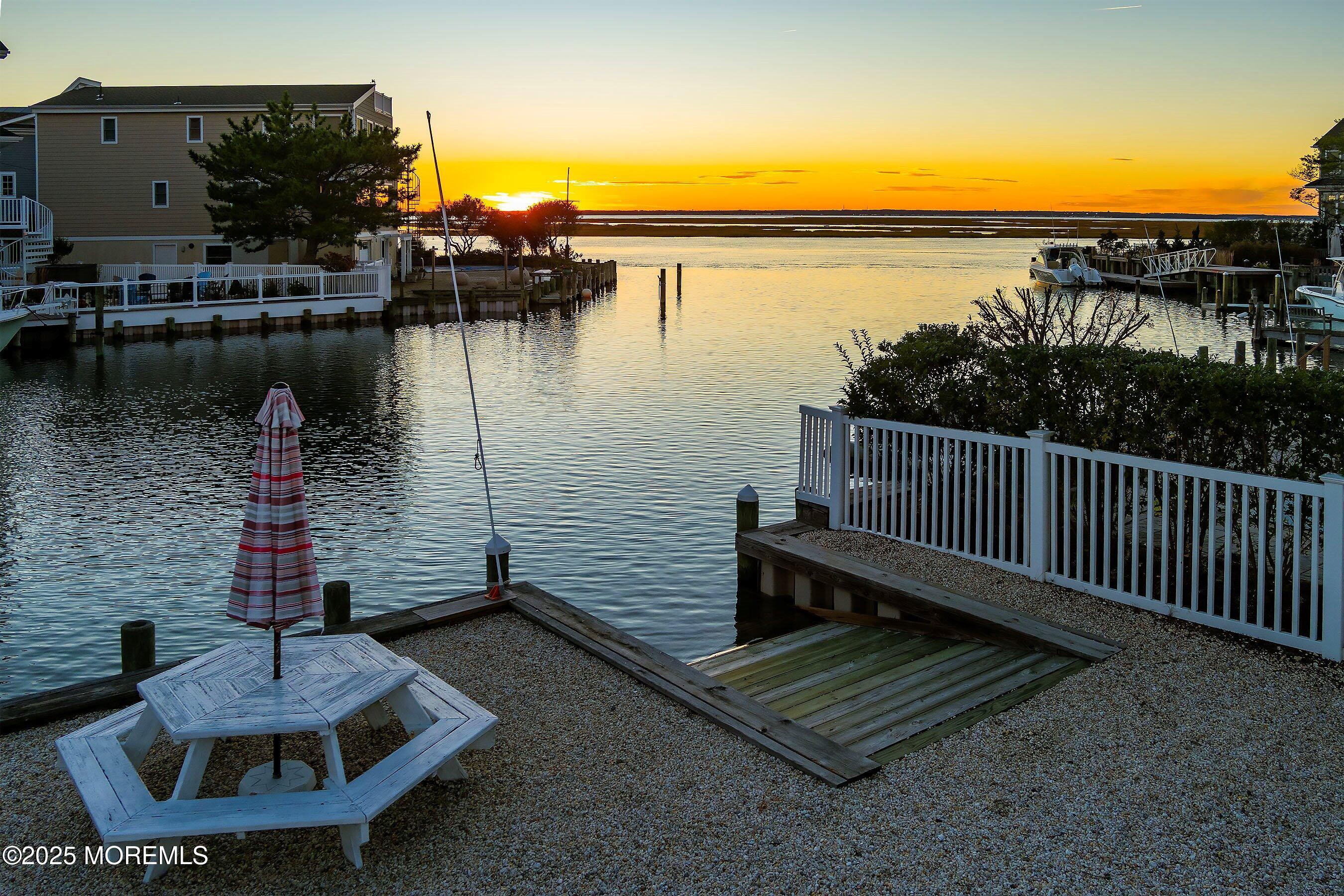 46 Adrian Road Barnegat Light, NJ 08006 - Photo 13 of 28 a wooden bench sitting next to a lake