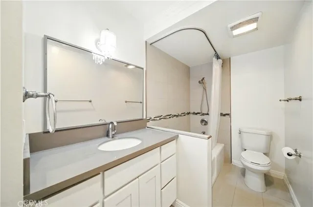 a bath room with a sink vanity granite and a mirror