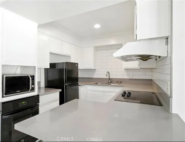 a kitchen with a sink a microwave a stove and refrigerator