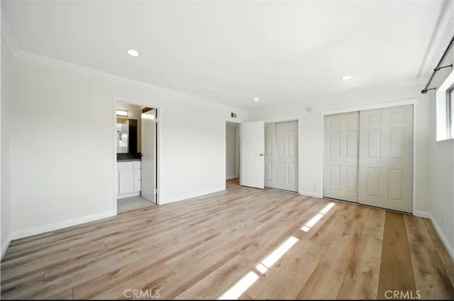 a view of an empty room with wooden floor