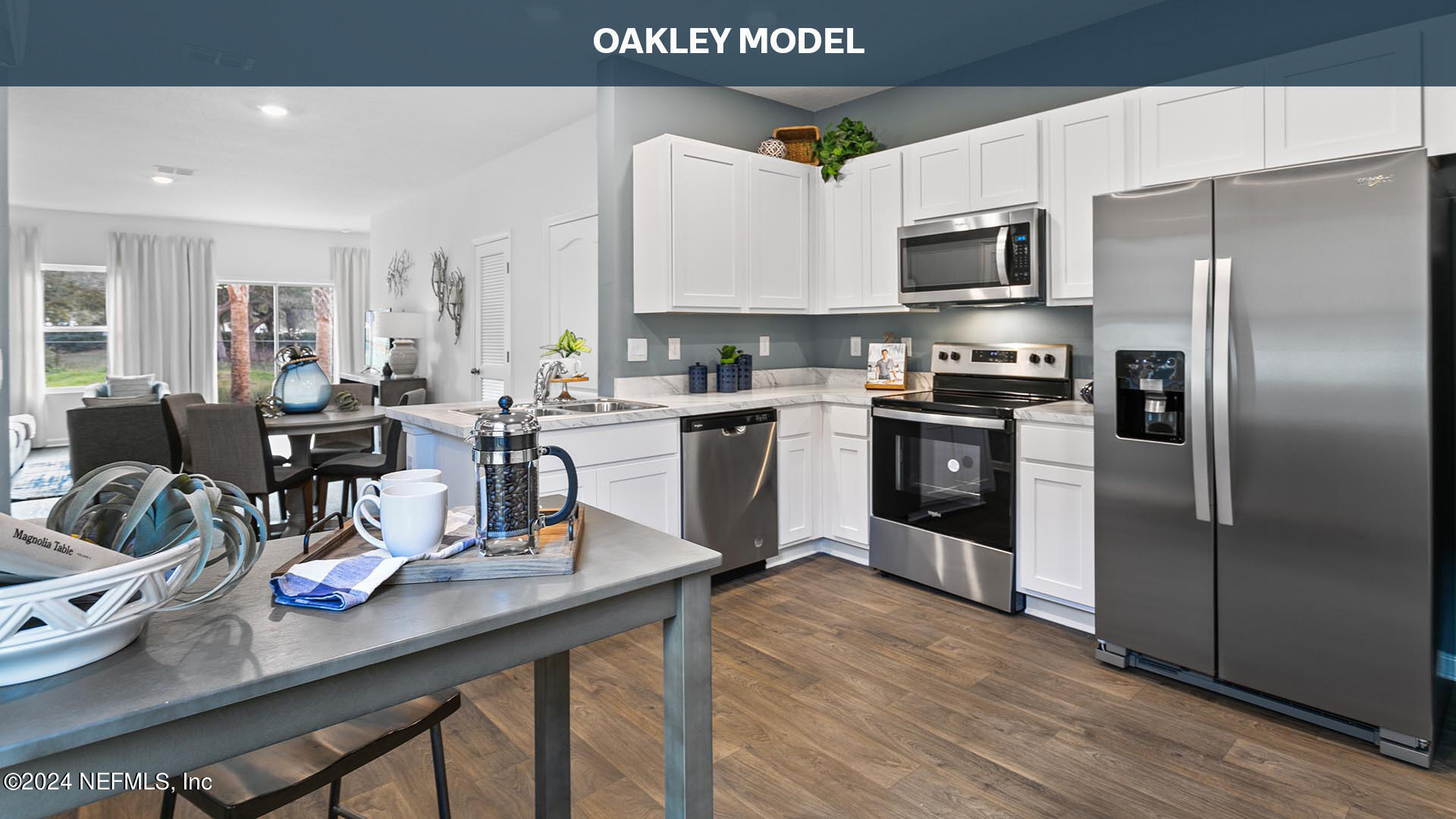 a kitchen with stainless steel appliances a sink a stove a refrigerator cabinets and a dining table