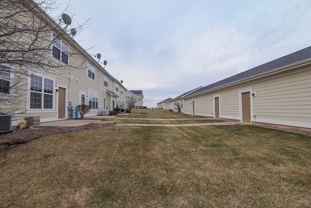 1240 Mariemont Road, Unit E Sugar Grove, IL 60554 - Photo 4 of 32 a view of a house with backyard and a tree