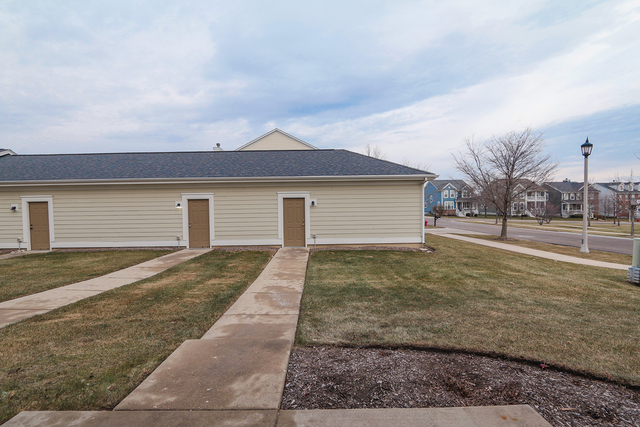 1240 Mariemont Road, Unit E Sugar Grove, IL 60554 - Photo 7 of 32 a front view of a house with a yard and garage