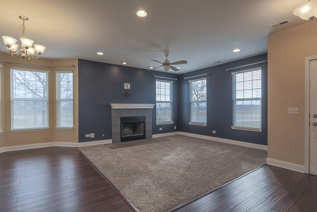 1240 Mariemont Road, Unit E Sugar Grove, IL 60554 - Photo 10 of 32 an empty room with windows fireplace and wooden floor