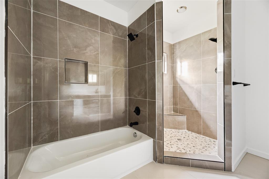 1014 Trinity Street Cleburne, TX 76031 - Photo 9 of 24 a bathroom with a bathtub and a shower