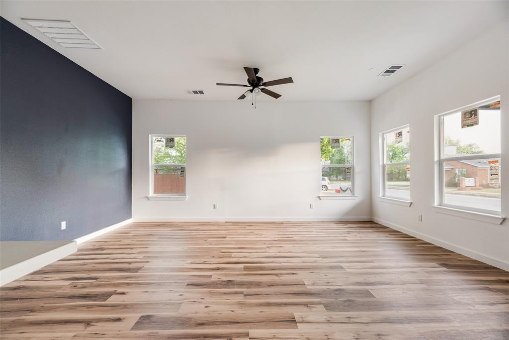 1014 Trinity Street Cleburne, TX 76031 - Photo 10 of 24 an empty room with windows and a ceiling fan