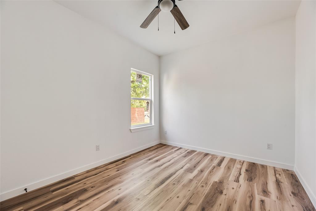 1014 Trinity Street Cleburne, TX 76031 - Photo 14 of 24 wooden floor in an empty room with a window