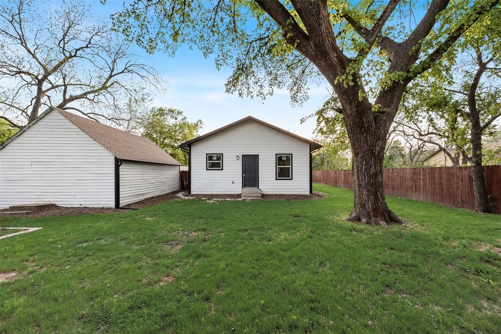 1014 Trinity Street Cleburne, TX 76031 - Photo 21 of 24 a view of a backyard with a large tree