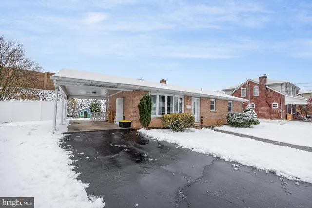 a front view of a house with a yard and potted plants