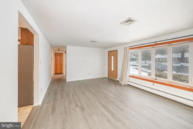 a view of a room with wooden floor and windows