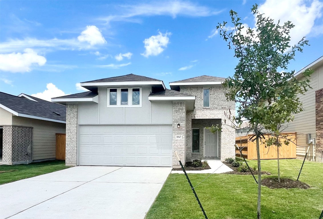 View of front of home featuring brick siding, concrete driveway, an attached garage, and a shingled roof