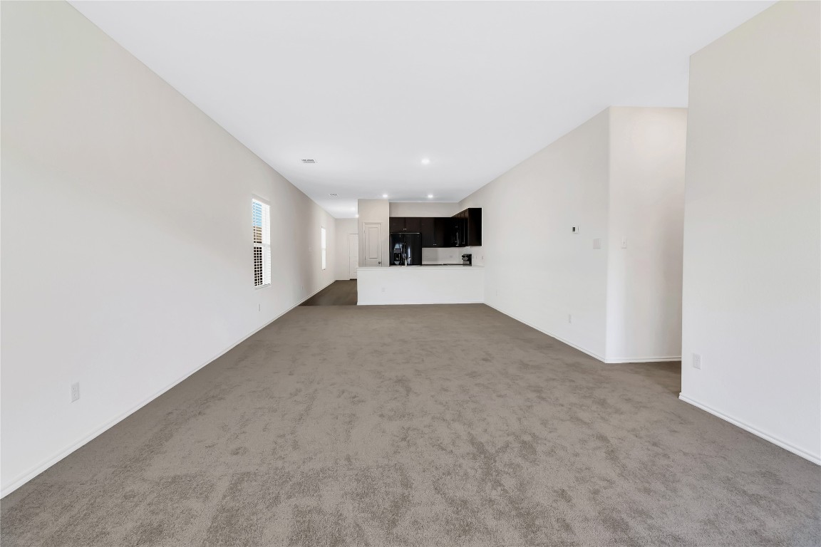 160 The Bad Way Jarrell, TX 76537 - Photo 12 of 33 Unfurnished living room featuring dark carpet and recessed lighting