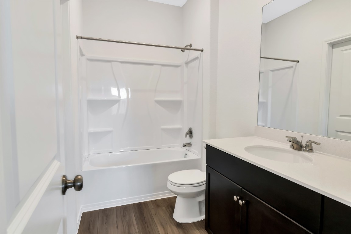 160 The Bad Way Jarrell, TX 76537 - Photo 15 of 33 Bathroom with vanity, bathing tub / shower combination, and dark wood-style flooring