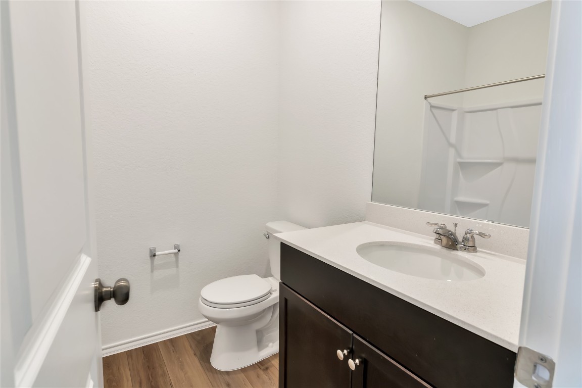 160 The Bad Way Jarrell, TX 76537 - Photo 22 of 33 Bathroom with vanity, dark wood finished floors, and a shower