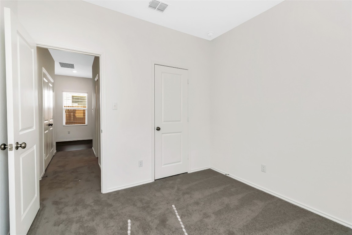 160 The Bad Way Jarrell, TX 76537 - Photo 26 of 33 Unfurnished bedroom featuring baseboards and dark colored carpet