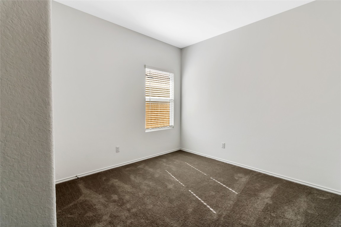 160 The Bad Way Jarrell, TX 76537 - Photo 27 of 33 Unfurnished room with dark colored carpet and baseboards
