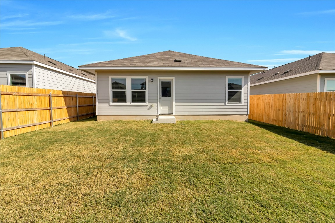 160 The Bad Way Jarrell, TX 76537 - Photo 31 of 33 Rear view of house featuring a fenced backyard and a shingled roof